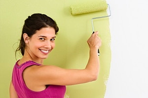 smiling woman painting a wall